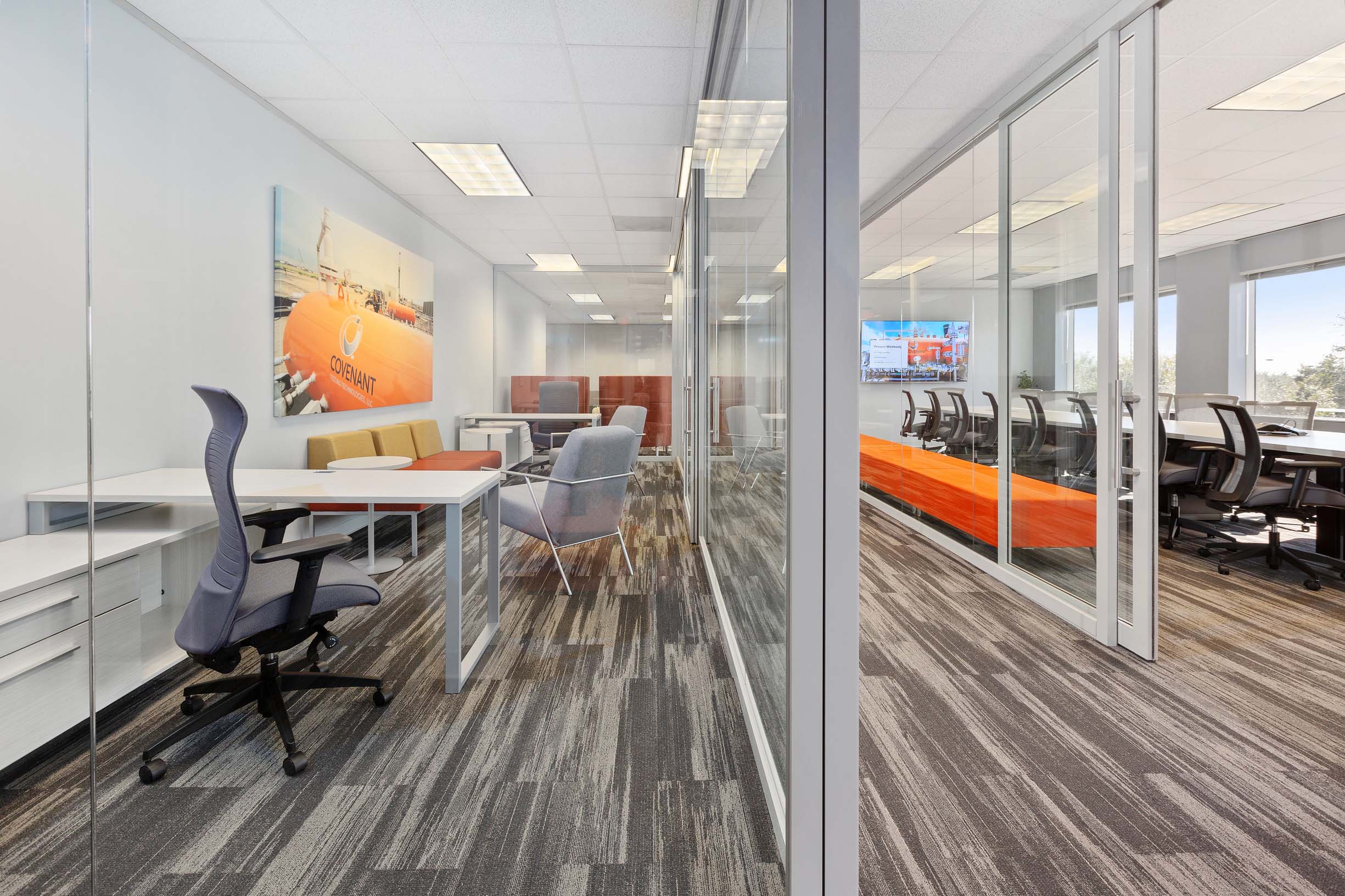 new office furnished in orange and grey with glass walls