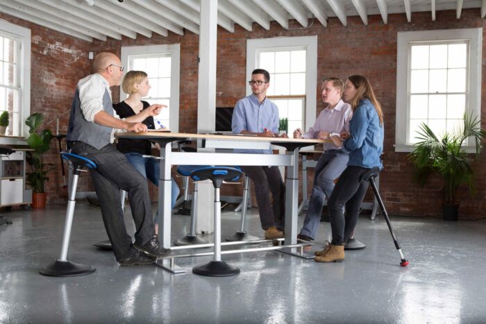 leaning seat at conference table in brick hipster office setting