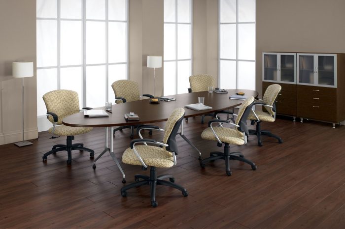 Studio photograph of six 5331-4 model Supra chairs placed at an oval conference table. Paned windows bring in light from the corner.