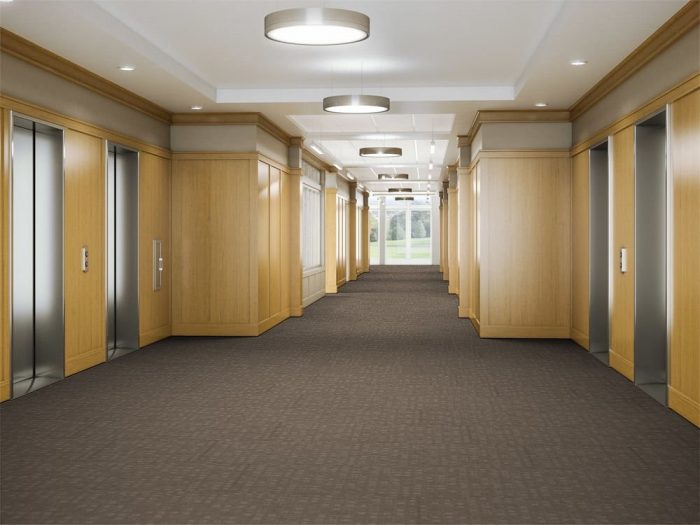 Looking down a hallway, leading to the elevator banks in a commercial building. The floor is lined in Oxford model carpeting.
