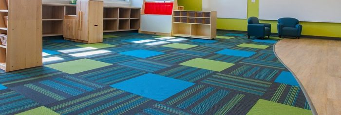 Studio photography inside a large classroom of the Lombard Early Childhood Center. Colorful squares of Pop carpeting are mixed in with the striped pattern of Boom carpet squares.