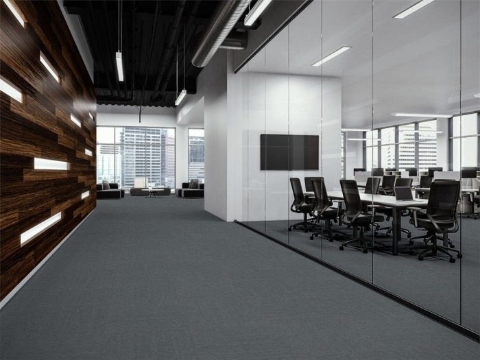 Transit carpet along a company corridor. There is glass walls to the left, looking into a large meeting space. At the end is guest seating looking out to the city.