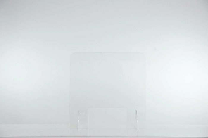 A small Counter Shield Lite screen placed on a table. One barely notices the screen as it fades into the light walls behind.