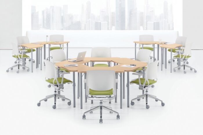 Light blonde laminate training tables with green cushioned seating